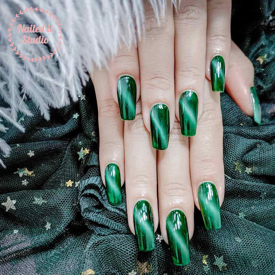 Green cat eye nail colour on hands.
